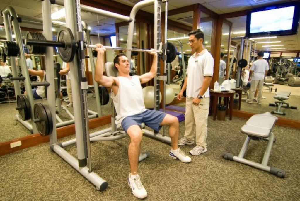 达沃市马可波罗酒店 外观 照片 A personal trainer assisting a client with a weight training exercise